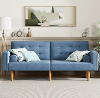 a blue sofa in front of a painting